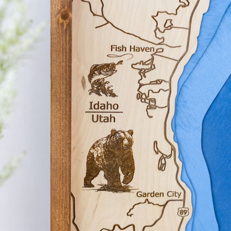 up close details of Bear Lake wooden map displaying engravings of bear and fish