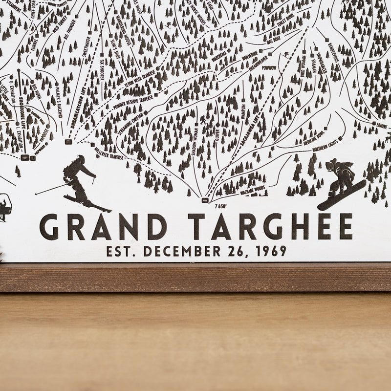 close up of Wooden ski map of Grand Targhee with engraved trails and skier silhouettes, including resort name and date
