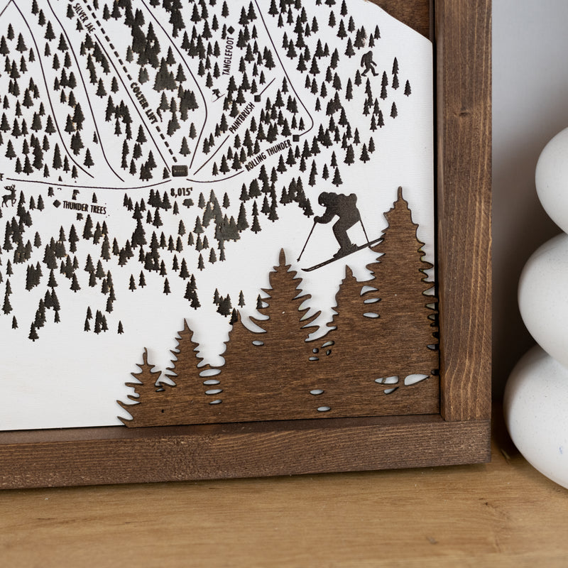 close up of bottom right corner of Wooden ski map of Grand Targhee displaying details of trails, trees, and skiers
