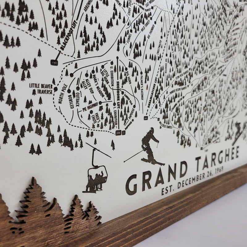 close up of Wooden ski map of Grand Targhee bottom left corner with engraved trails and skier silhouettes, including resort name and date